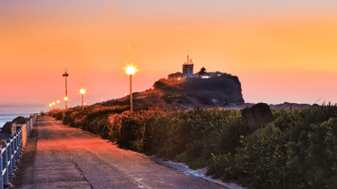 Nobbys light house with pink and orange sunset behind